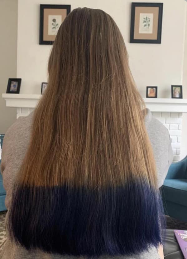 Long brown hair with the ends dip dyed dark blue in a straight line bad haircut