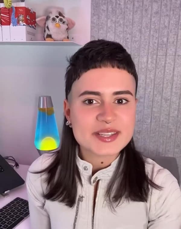 A person with a mullet style bad haircut featuring extremely short micro bangs.