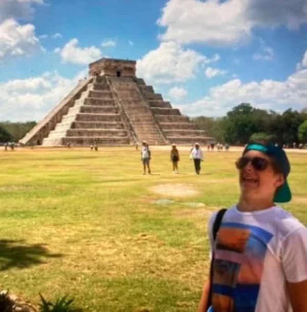 Tourist making awkward face in front of Mayan pyramid blunder years.