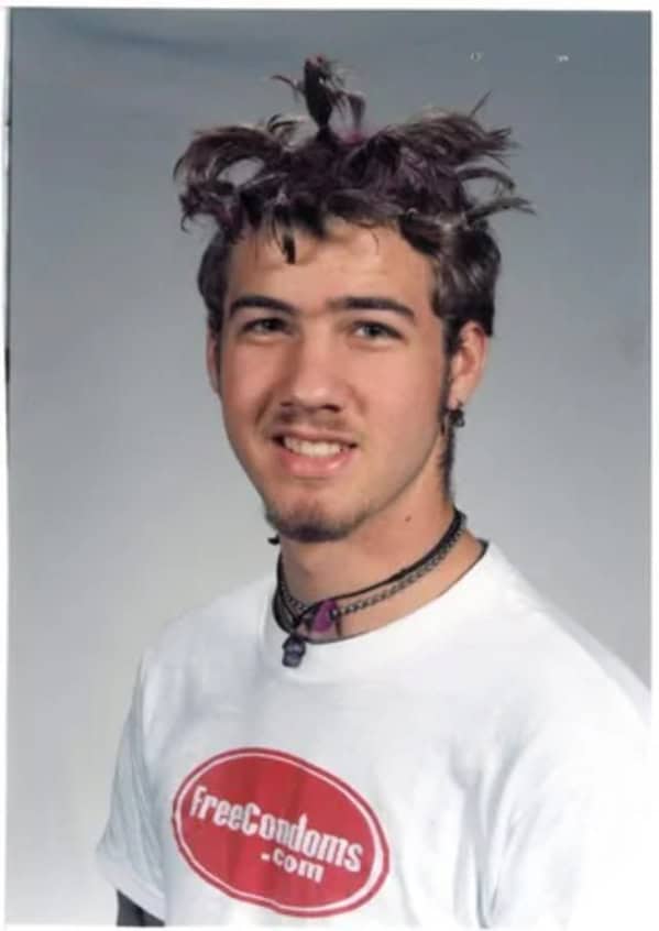 Teenager wearing Free Condoms dot com t-shirt blunder years.