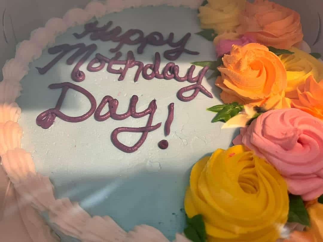 A funny cake fail with blue icing and a typo reading Happy Mothday Day instead of Mother's Day.