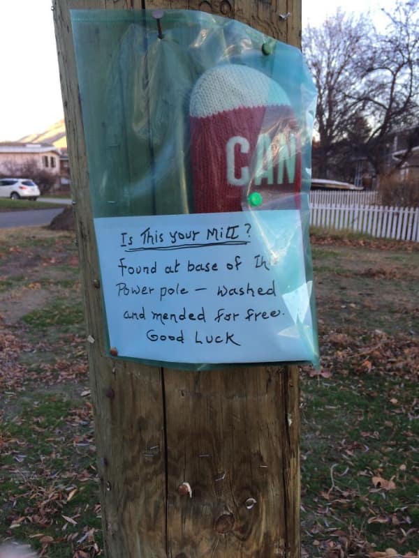 Note on utility pole about a lost mitten being washed and mended.