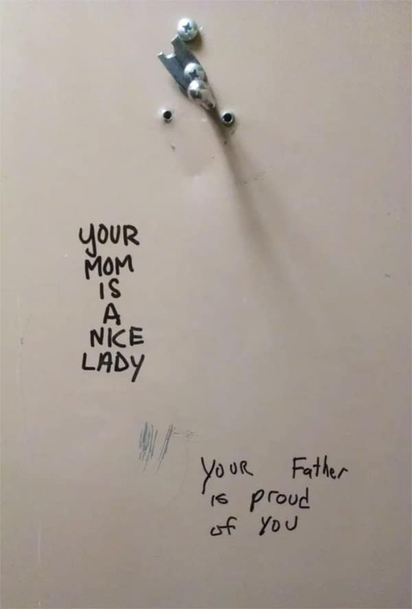 Wholesome bathroom stall graffiti complimenting someone's mother and father.