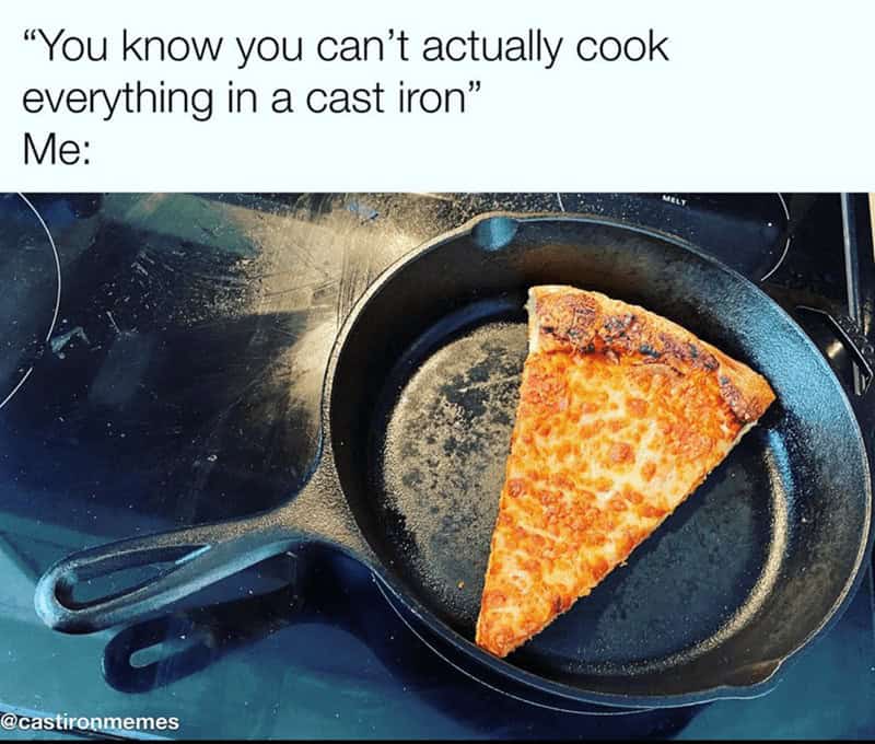 Single slice of pizza being reheated in a large black cast iron skillet.