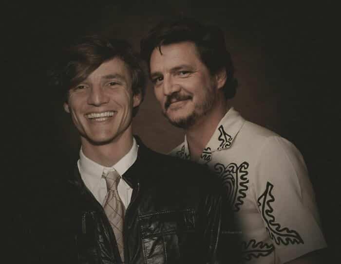 Pedro Pascal smiling next to his younger self in a leather jacket.