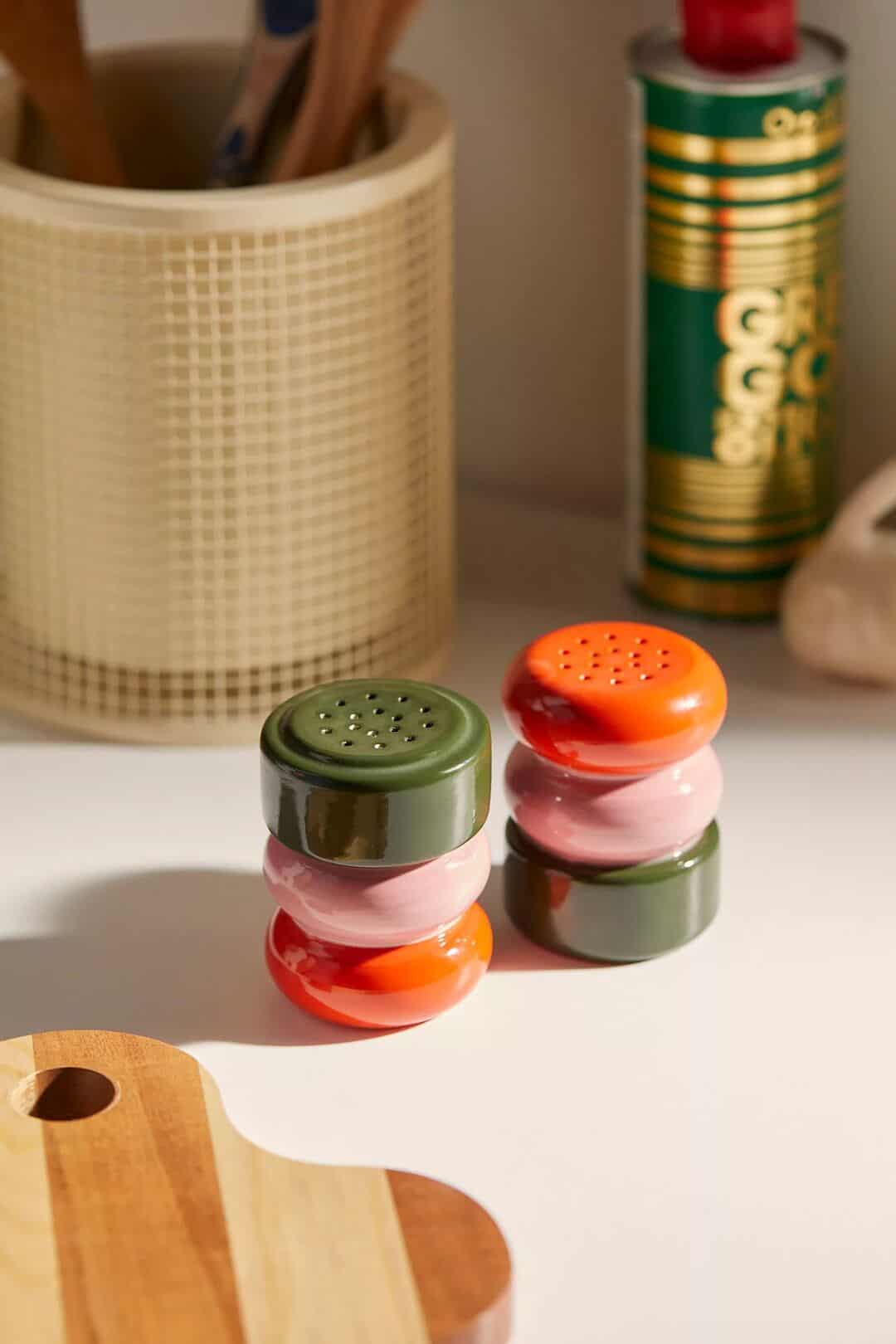 Colorful ceramic salt and pepper shakers shaped like stacked pebbles in green, pink, and orange