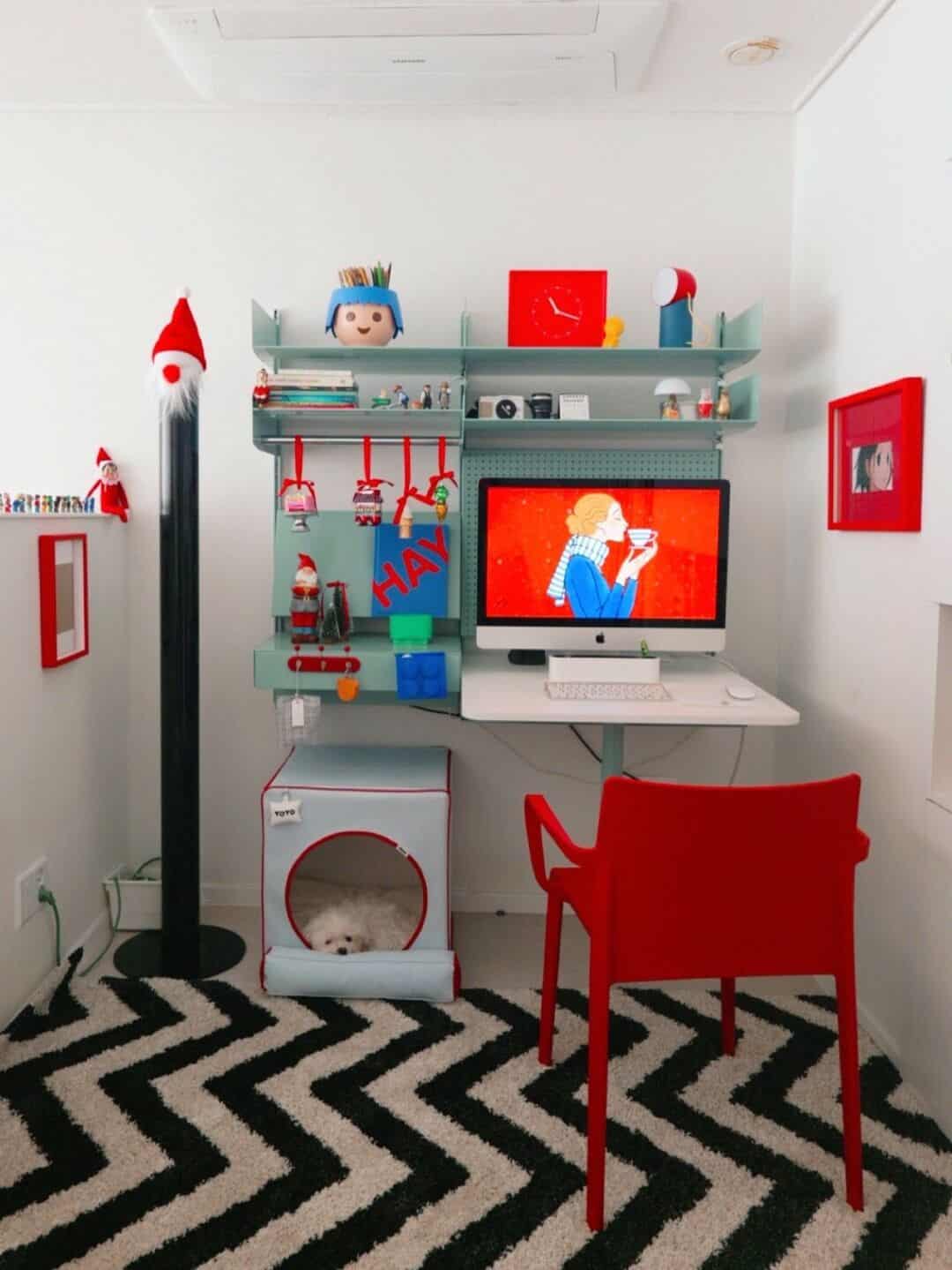 An awesome interior design workspace with a red chair, zigzag rug, and organized shelving unit