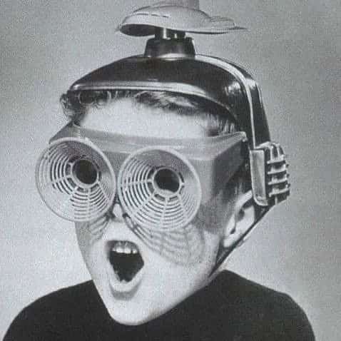 Young boy screaming while wearing futuristic oversized goggle apparatus with fans and antennas.