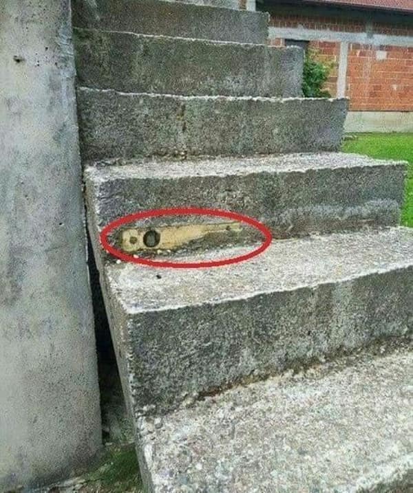 A cursed image of a concrete step with a rusty knife blade embedded in the edge.