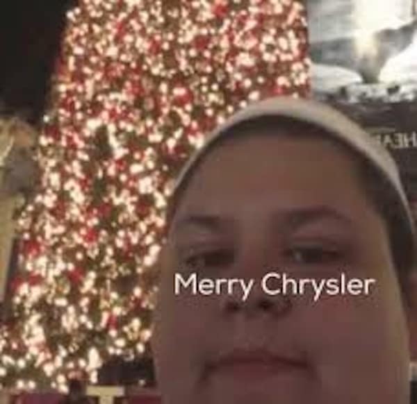 A famous meme of the Merry Chrysler guy standing in front of a Christmas tree.