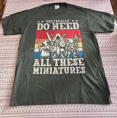 A dnd meme photo of a t-shirt stating "Yes I Really Do Need All These Miniatures" with retro rpg art.