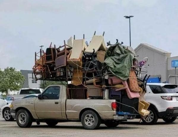 A driving fail showing a pickup truck stacked impossibly high with dozens of chairs and furniture items.