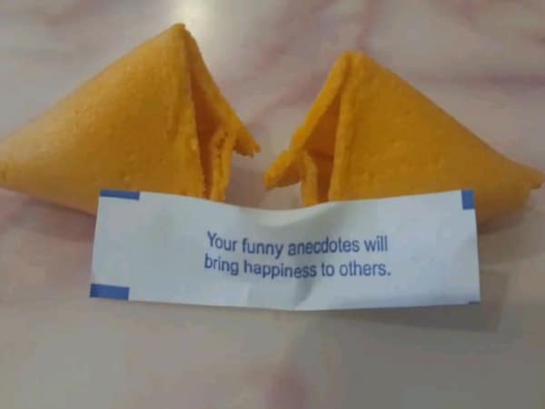 Broken fortune cookie with text saying your funny anecdotes will bring happiness.