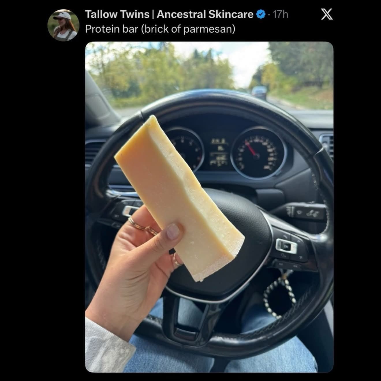 Person holding a large block of parmesan cheese describing it as a protein bar.