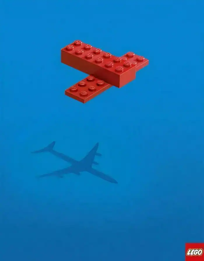 A funny print ad by LEGO showing two simple red bricks casting a shadow that looks like a complex airplane.