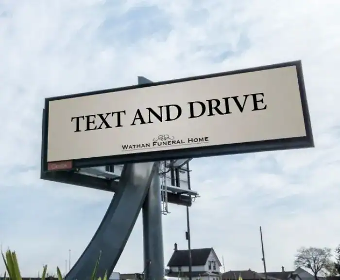 A dark humor funny print ad on a billboard for Wathan Funeral Home that encourages drivers to "Text and Drive."