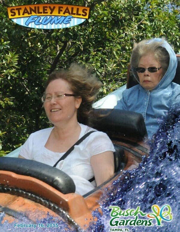 A funny rollercoaster picture showing a woman smiling in the front seat while an older woman in the back looks completely unimpressed.