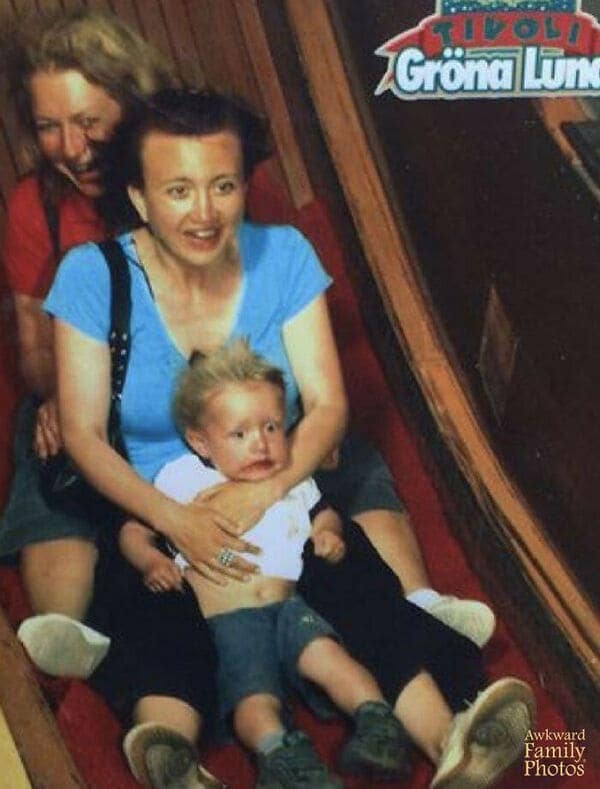 A funny rollercoaster picture of a toddler looking completely traumatized and staring into the void on a theme park ride.