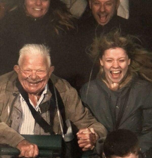 A heartwarming and funny rollercoaster picture of an elderly man with oxygen laughing hysterically on a thrill ride.