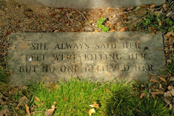 A funny tombstone flat marker joking about her feet killing her and no one believing it.