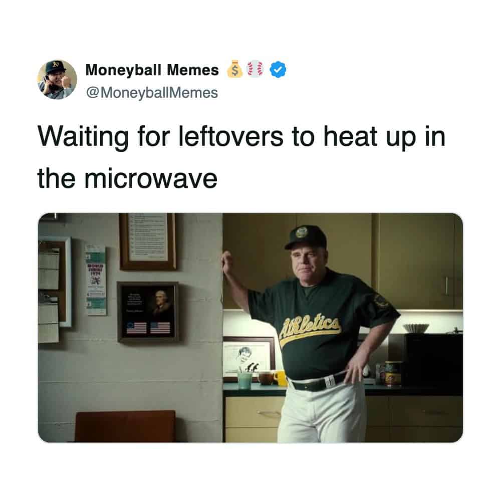 A funny tweet using a scene from Moneyball to represent standing awkwardly while waiting for a microwave.
