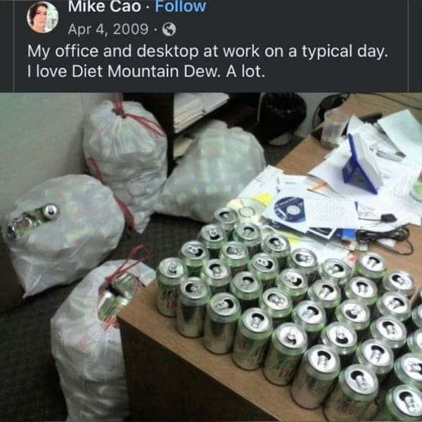 Office cubicle filled with massive bags of empty Diet Mountain Dew cans.
