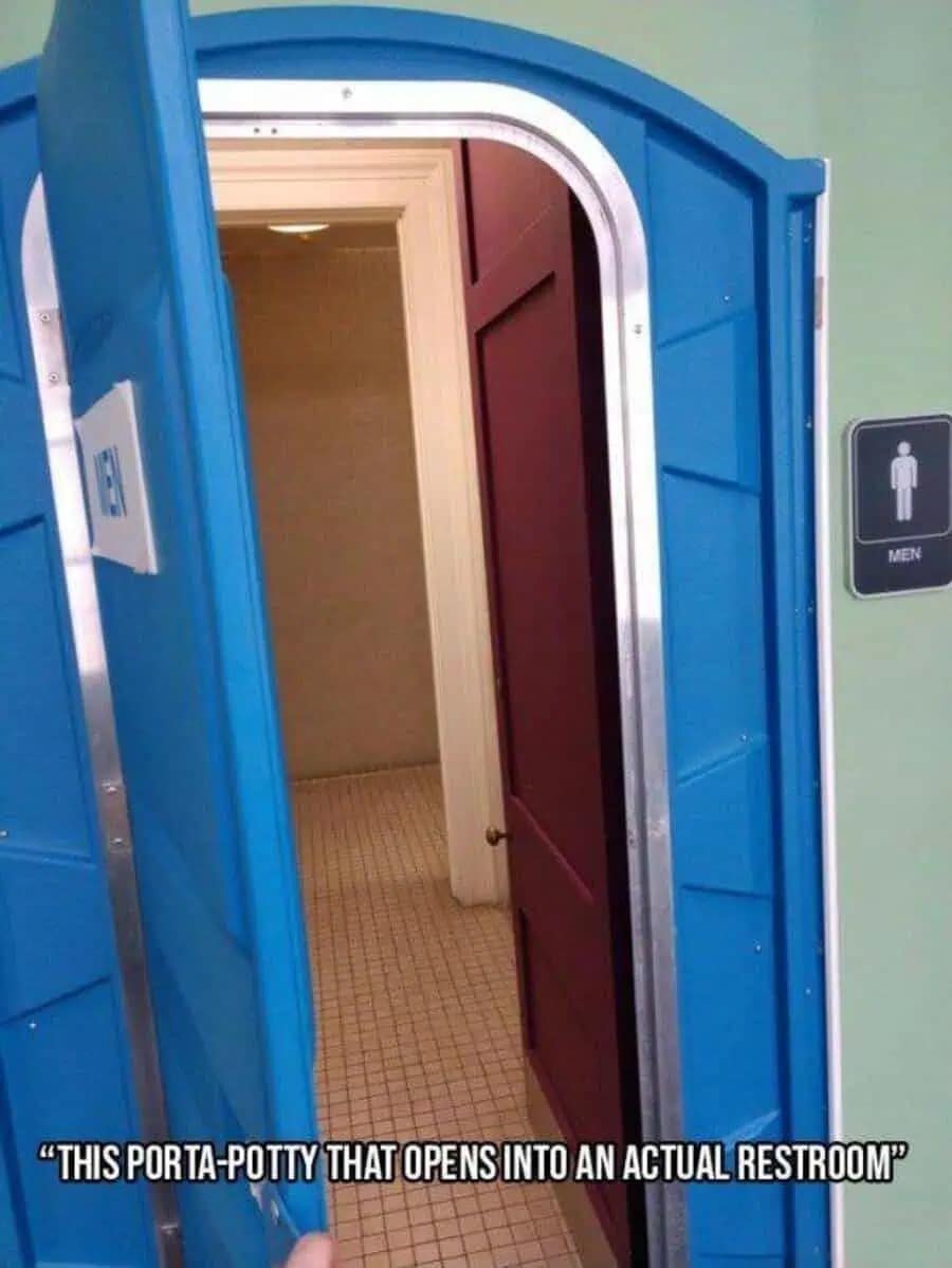 A photo of a blue portable toilet door opening up to reveal a clean, tiled indoor bathroom