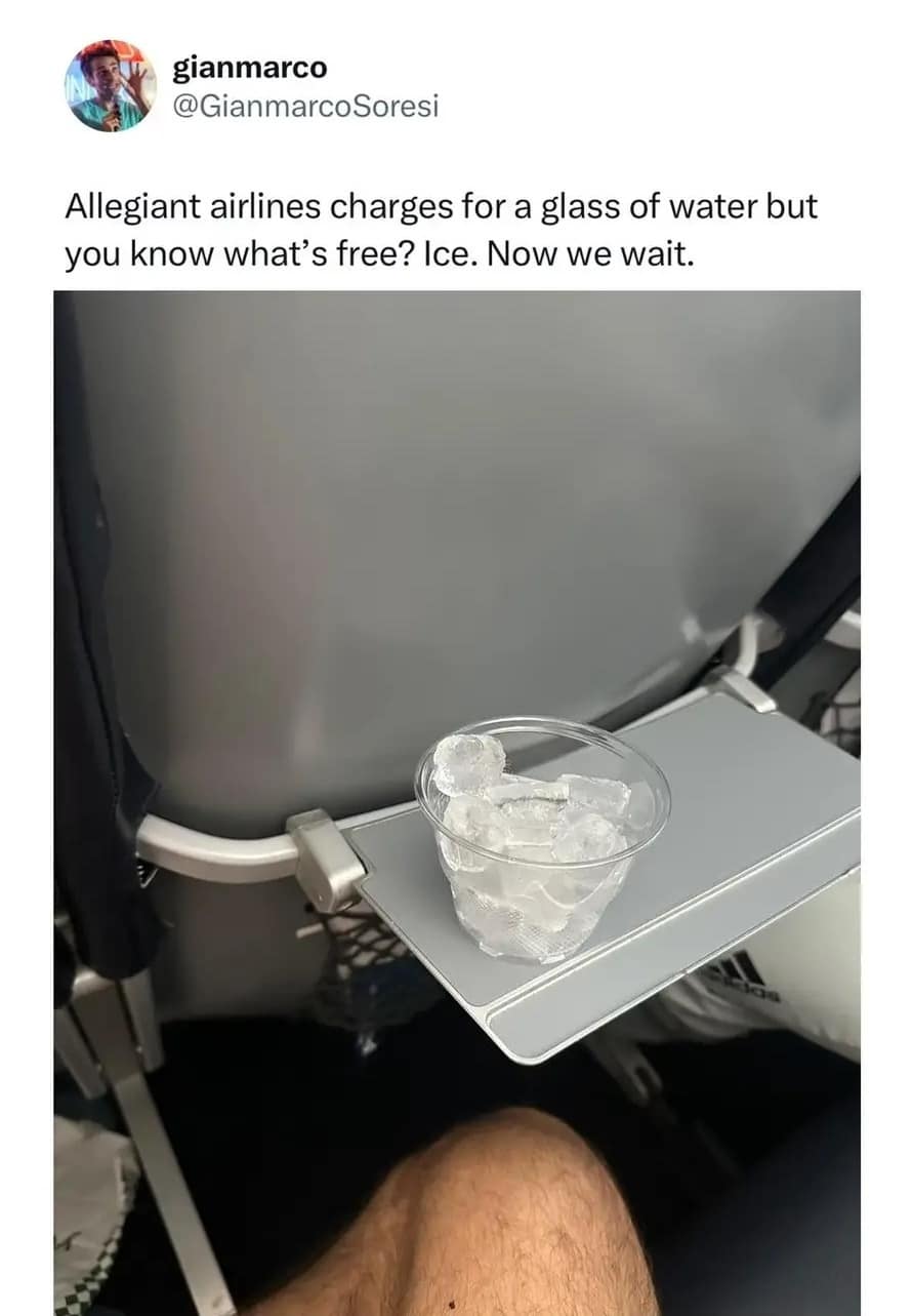A hilarious meme photo showing a cup of ice on a plane tray table as a hack to avoid paying for water.