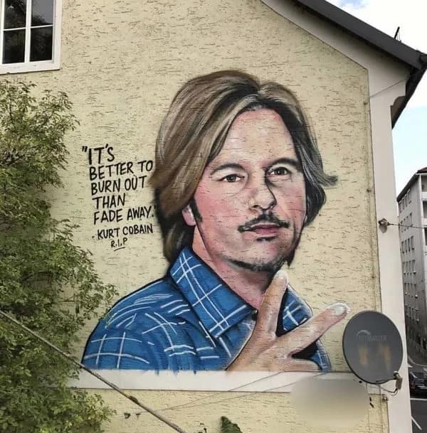 A funny meme photo of a mural depicting David Spade but mislabeled as Kurt Cobain with a quote.