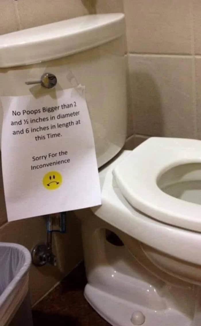 Toilet sign restricting poop dimensions to specific length and width measurements.