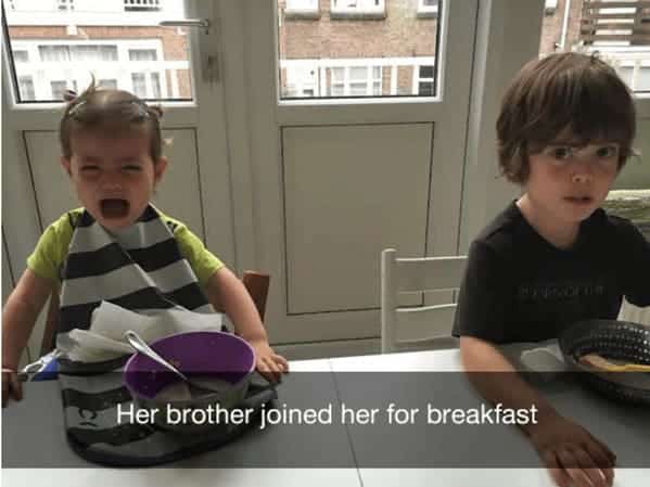 Girl crying at the table because her brother sat down to eat breakfast with her.