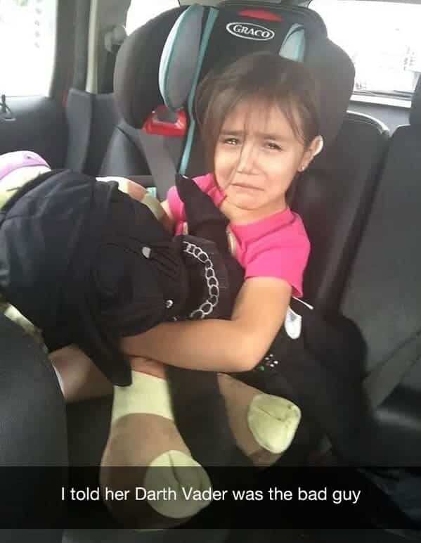 Little girl crying while hugging a Darth Vader plush toy after learning he is a villain.