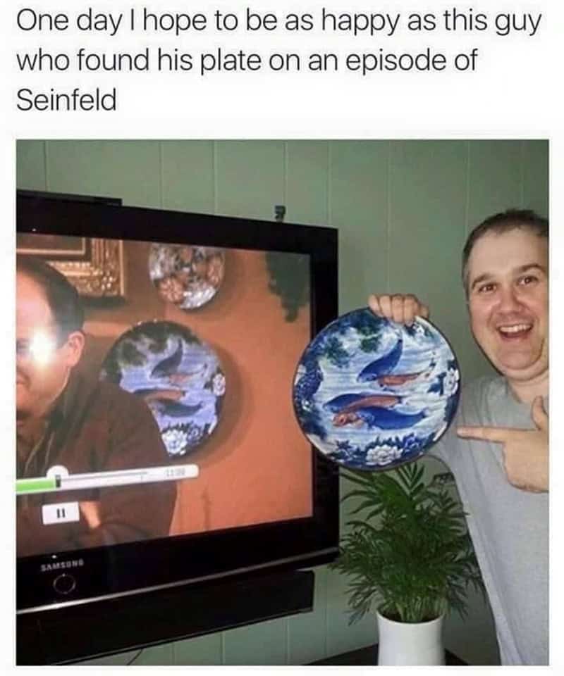 Fan holding blue plate matching the prop on George's parents' wall.