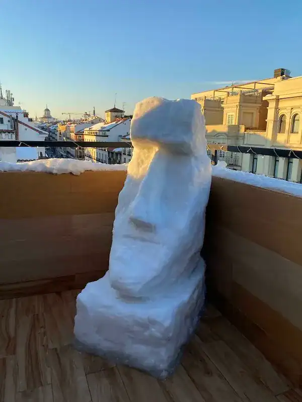 Easter Island Moai head snow sculpture on a balcony.