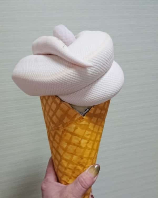White snake coiled perfectly on top of a waffle cone resembling vanilla soft serve.