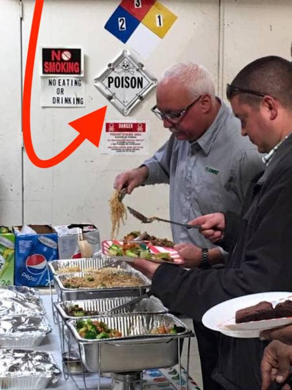 ood buffet line set up directly under poison and chemical hazard signs.
