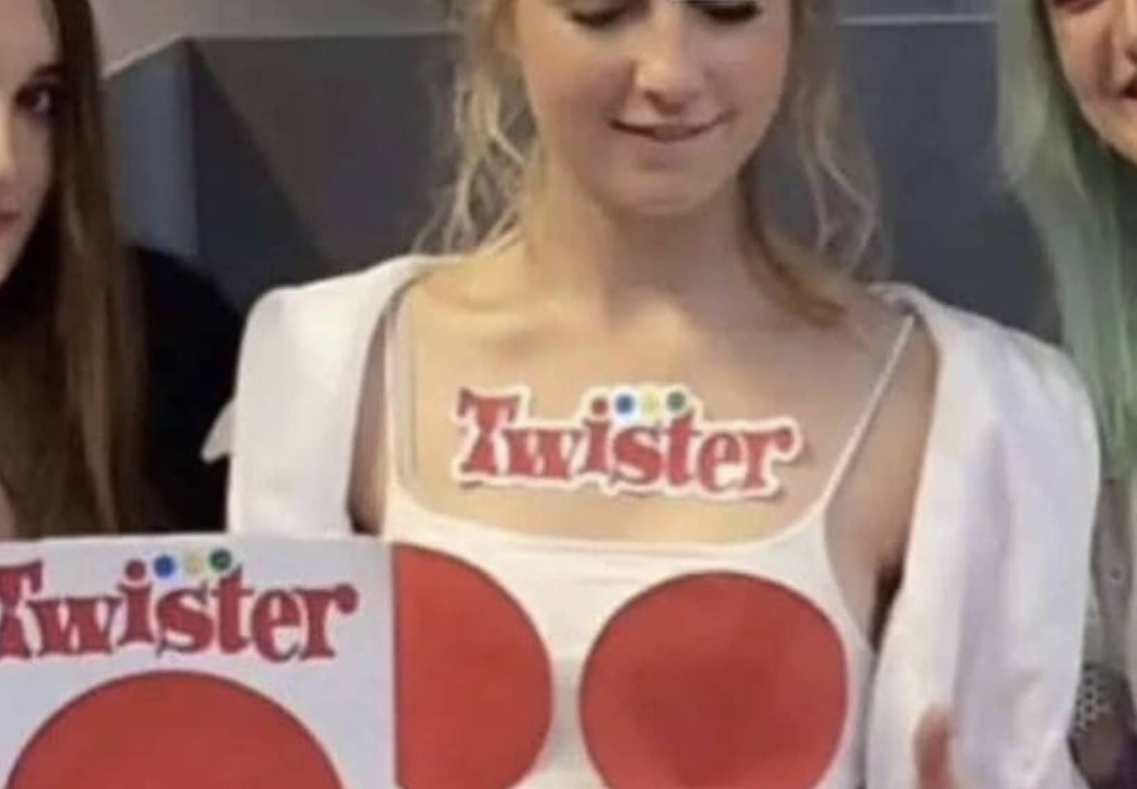 Young woman wearing a creative Twister board game costume with red circles and logo.