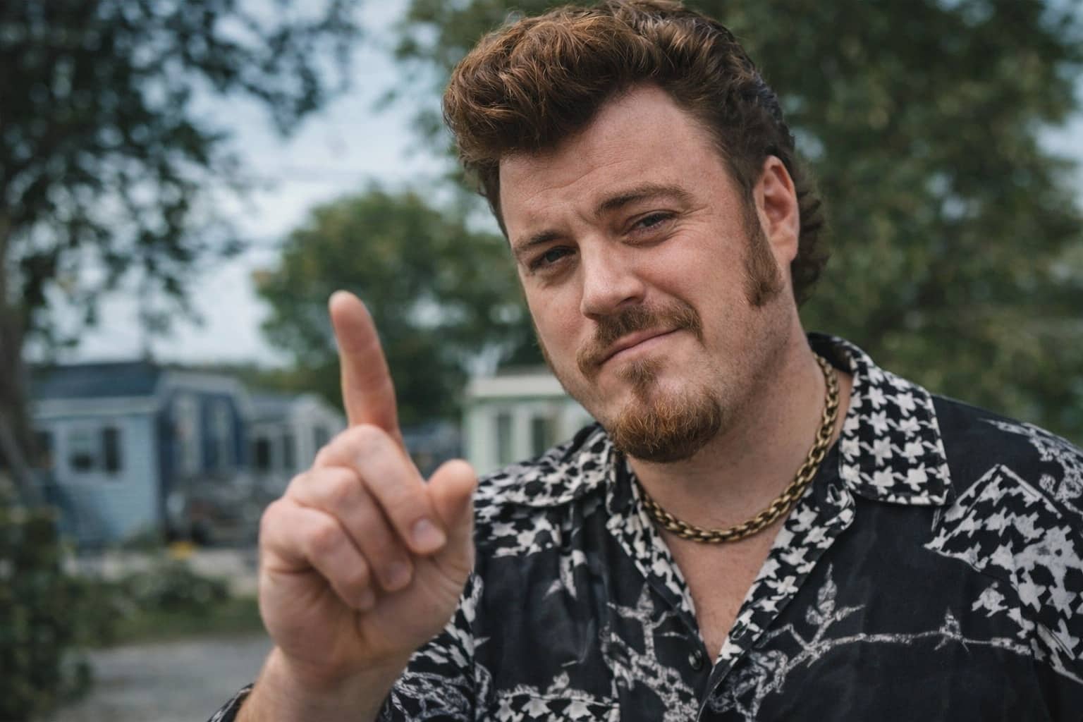 Man with a pompadour hairstyle and track jacket pointing, inspired by Rickyisms and mockumentary humor.