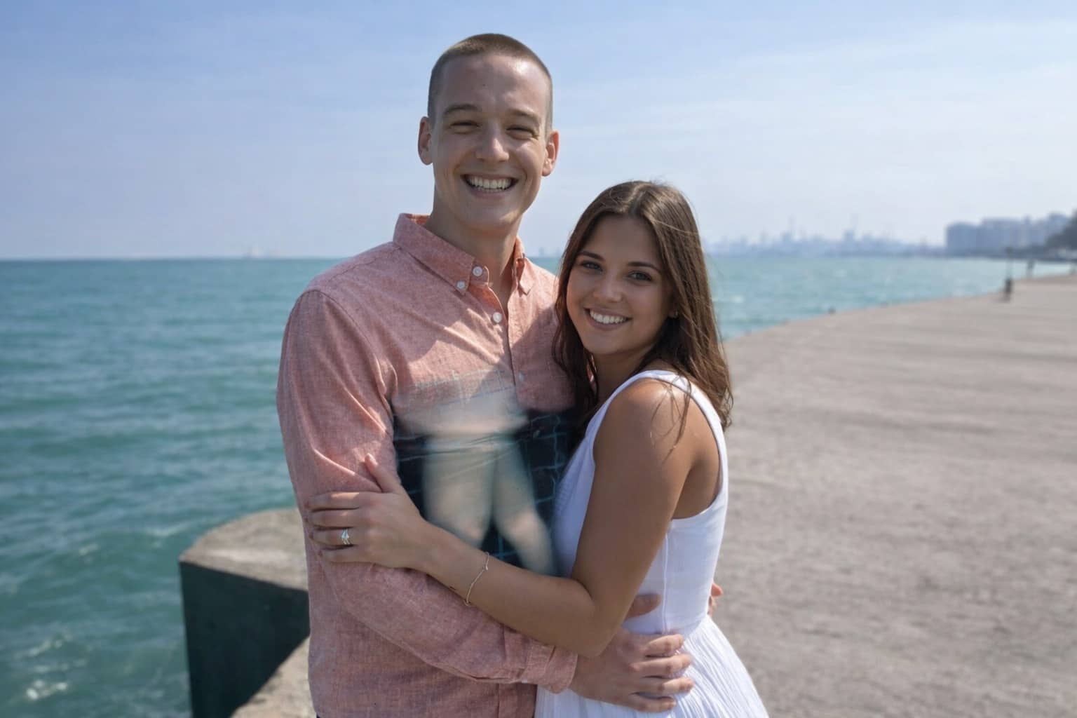 Smiling couple on a beach pier with a confusing perspective illusion on the man's shirt.