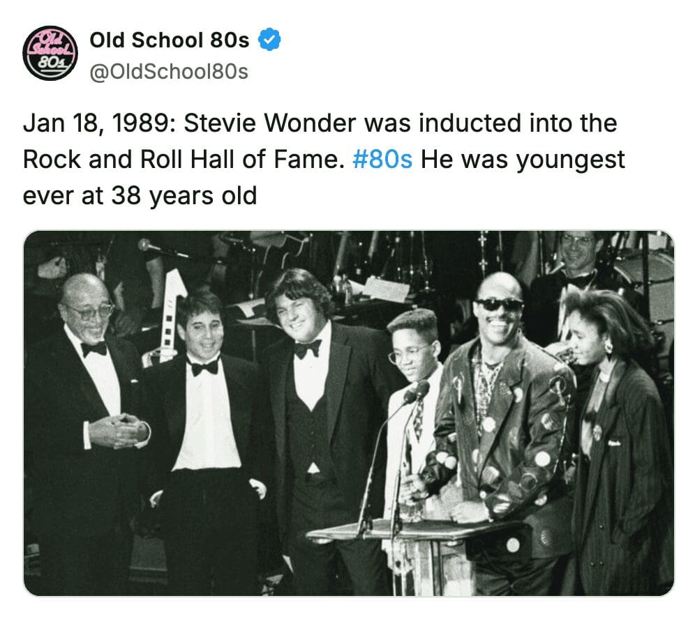 Stevie Wonder smiling at a podium during his 1989 Rock and Roll Hall of Fame induction.