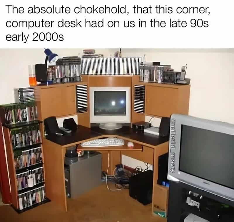 Classic late 90s wooden corner computer desk filled with CD towers, a CRT monitor, and bulky speakers.