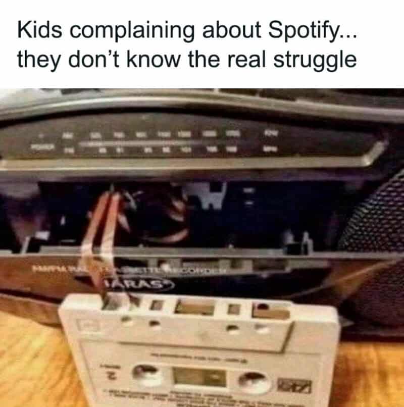 Close-up of a tangled cassette tape being pulled out of a boombox, referencing pre-Spotify music struggles.