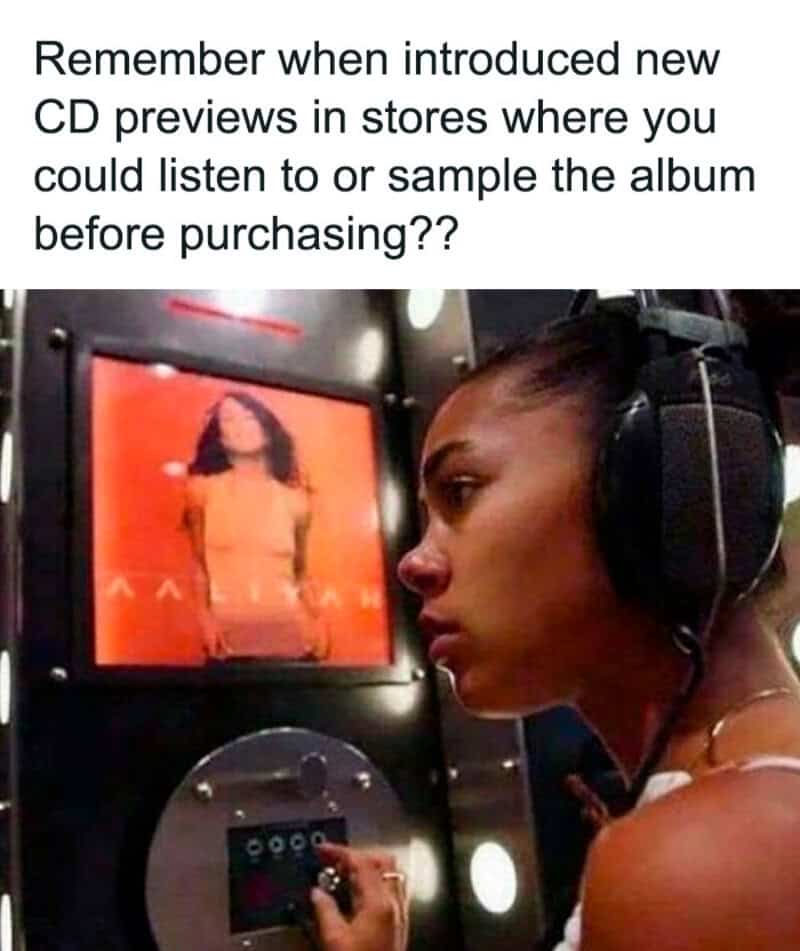 Woman wearing large headphones at an in-store CD listening station featuring an Aaliyah album preview.