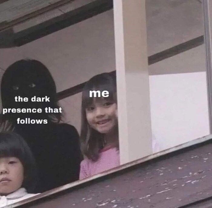 A classic format in anxiety memes showing a smiling little girl looking out a window labeled "me," while a terrifying, shadowy figure with glowing eyes stands right behind her labeled "the dark presence that follows".