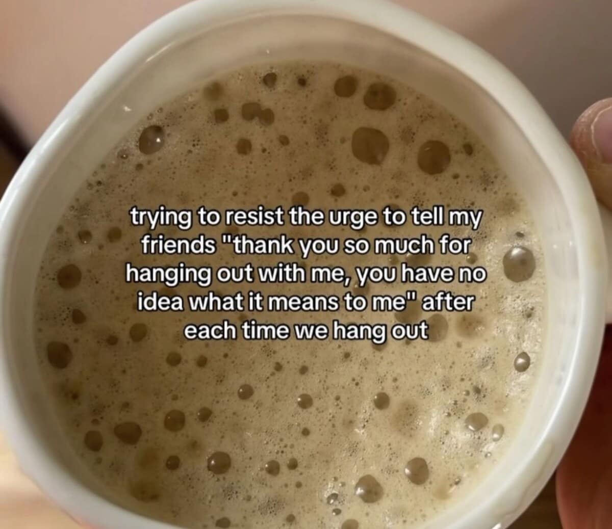 A wholesome yet anxious classic meme text overlay on a coffee cup, describing the struggle to not aggressively thank friends for hanging out due to overwhelming gratitude.