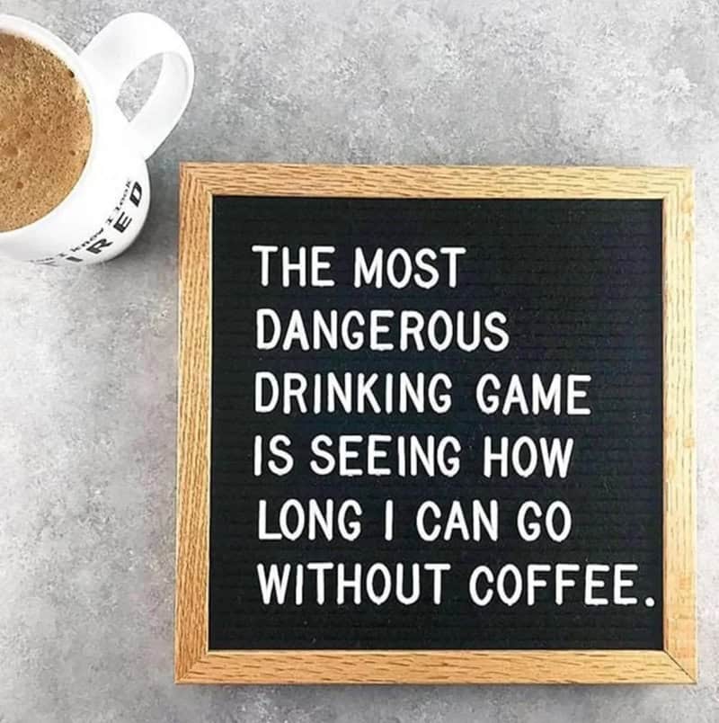 Coffee meme: A black letter board next to a white mug on a grey surface. Text: "THE MOST DANGEROUS DRINKING GAME IS SEEING HOW LONG I CAN GO WITHOUT COFFEE."