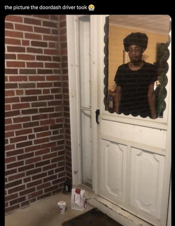 A door dash meme showing a proof of delivery photo where the driver's reflection in the glass door looks completely defeated.
