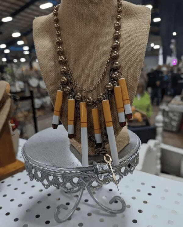 A statement necklace made entirely of used-looking cigarette butts and gold chains, the ultimate fashion faux pas.