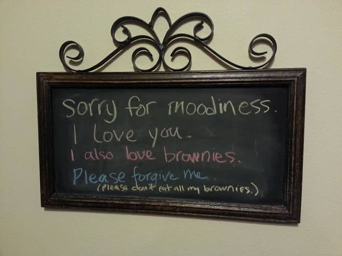 Chalkboard note apologizing for moodiness while requesting that the recipient not eat the writer's brownies.