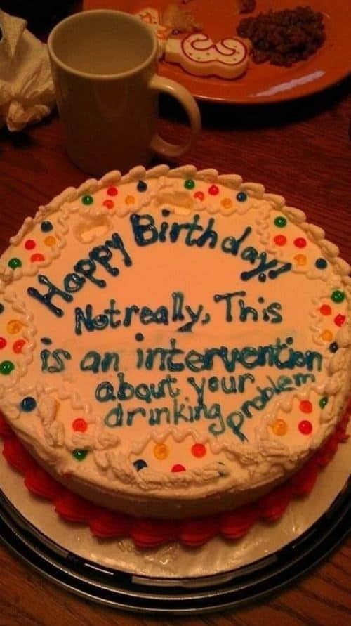 A funny cake that appears to be for a birthday but actually features icing text stating this is an intervention about your drinking problem.